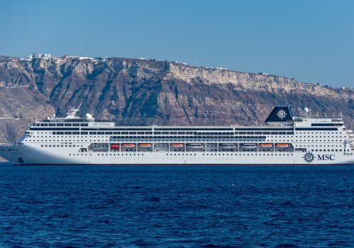 Fira, Greece - July 16 2019:   The Swiss based Cruise ship MSC Sinfonia anchored in the Aegean Sea off the coast of Santorini near Fira